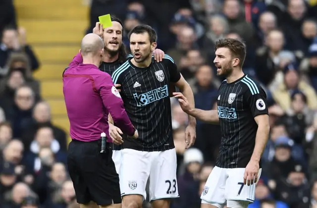 Gareth McAuley is shown a yellow card