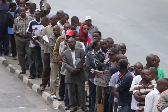 Kenyans seen in a queue leading into the Nairobi Primary Polling station