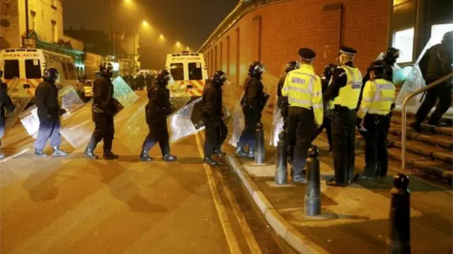 Officers with riot shields entering prison buildings