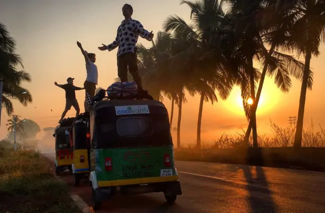 The team standing on top of their tuk-tuks