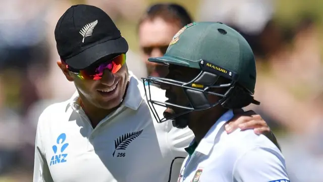 New Zealand's Neil Wagner (L) walks from the field with Bangladesh's Imrul Kayes