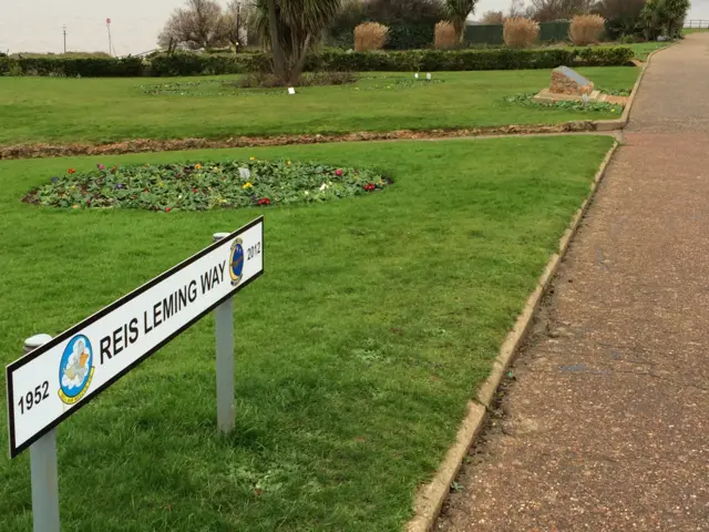 A sign for Reis Leming Way, near the memorial