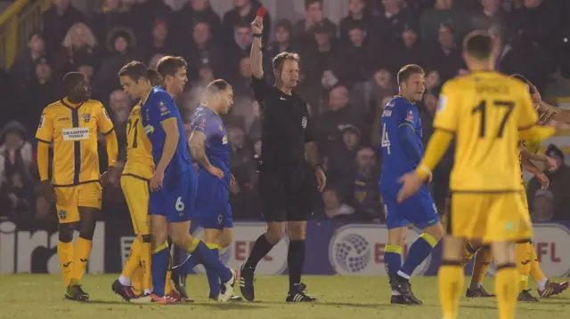 Wimbledon's Paul Robinson is shown a red card