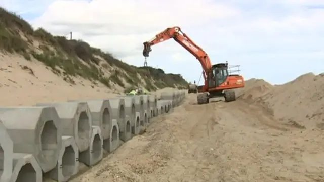 Hexagonal blocks being installed on the coastline