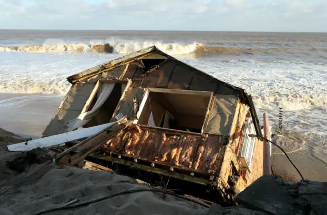 A bungalow falls into the sea in December 2013