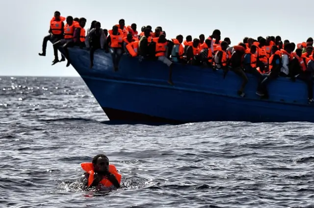 Migrants wait to be rescued as they drift in the Mediterranean Sea some 20 nautical miles north off the coast of Libya on October 3, 2016.