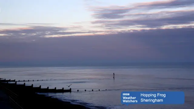 Early morning, showing gloomy sky hiding sun, over Sheringham beach