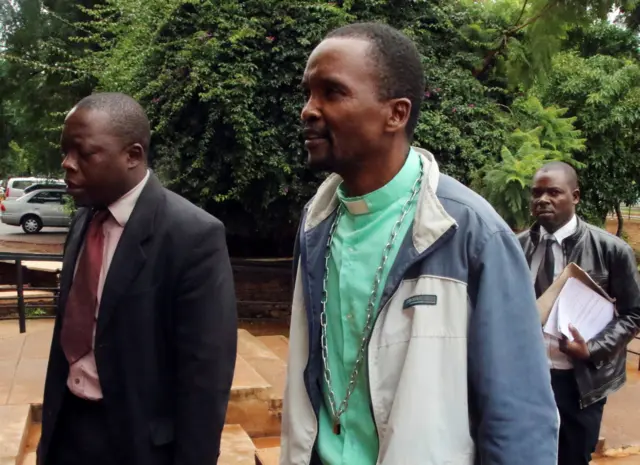 Patrick Mugadza, right, arriving at court in Harare, Zimbabwe