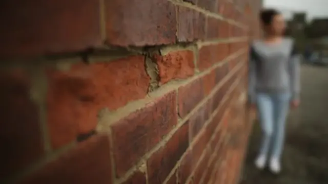 Stock picture of girl by wall with pixellated face