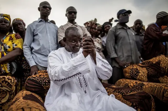 Adama Barrow, the flag-bearer of the coalition of the seven opposition political parties in Gambia, greets supporters during a gathering in the buffer Zone district of Talinding on November 29, 2016