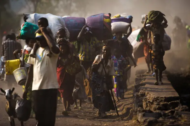 Displaced Congolese flee on July 15, 2013 the area of Kanyarucinya through Munigi on the outskirts of Goma in the east of the Democratic Republic of the Congo.