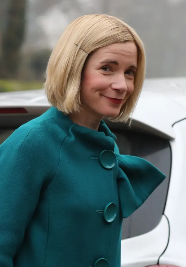 Historian Lucy Worsley, in aqua coloured coat, arriving at the village hall