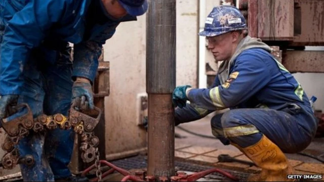 Fracking workers looking at drill