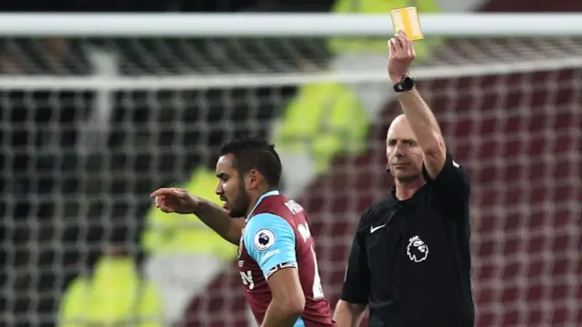 Dimitri Payet of West Ham United is shown a yellow card