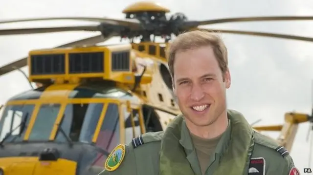 Prince William standing in front of an air ambulance helicopter