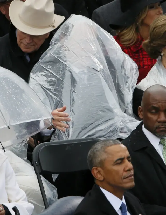 George W Bush covers himself from rain