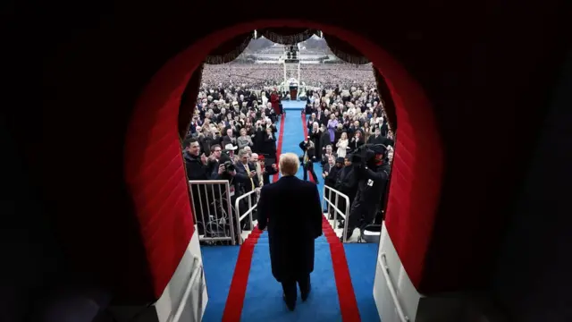 Trump walks through the doorway to the inauguration podium