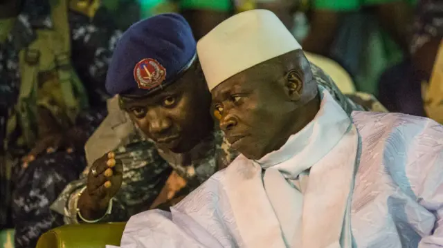 November 29, 2016 shows Gambian President Yahya Jammeh listening to one of his aides in Banjul, during the closing rally of the electoral campaign of the Alliance for Patriotic Reorientation and Construction