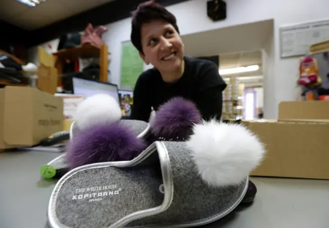 A seller shows White House slippers produced in the local shoe manufactory "Kopitarna" in downtown Sevnica, Slovenia