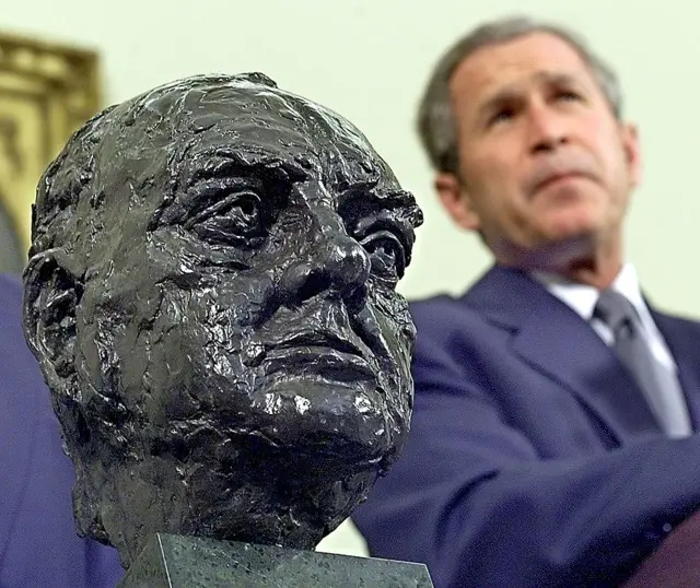 George W Bush listens to questions from reporters after receiving the bust in 2001