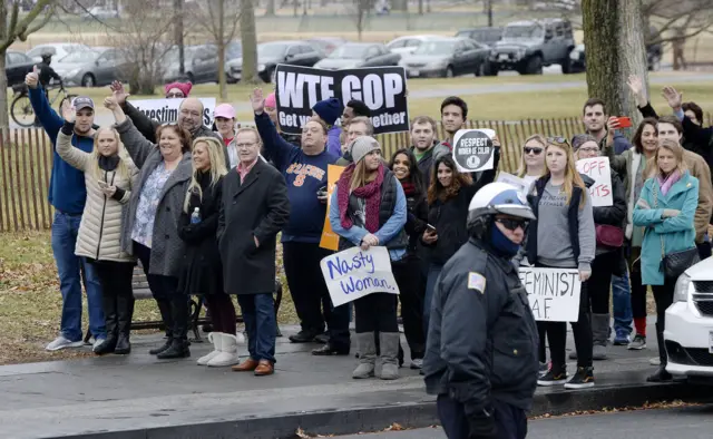 Protesters from the Women's March watch the Trump motorcade