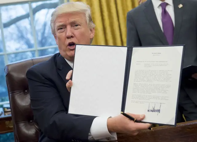 Donald Trump with order withdrawing US from TPP