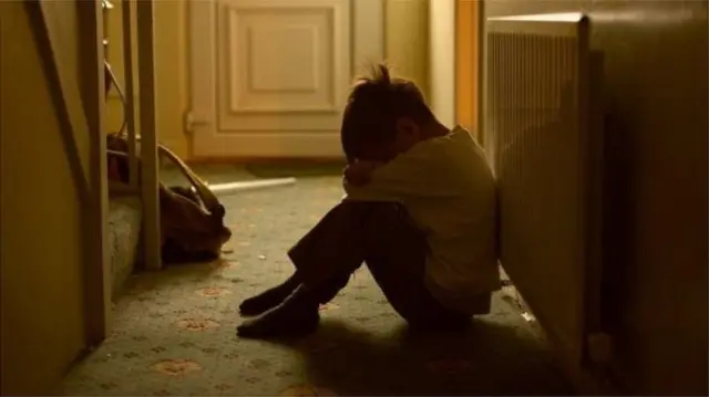 A child sitting with his head in his hands