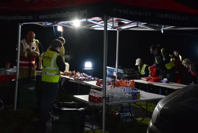 Night scene of fire crews getting drinks