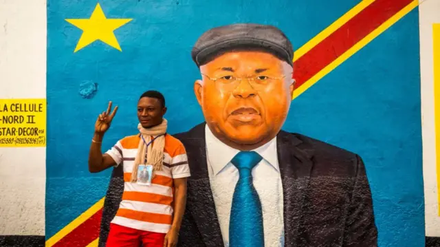 Supporter in front of painting of Etienne Tshisekedi