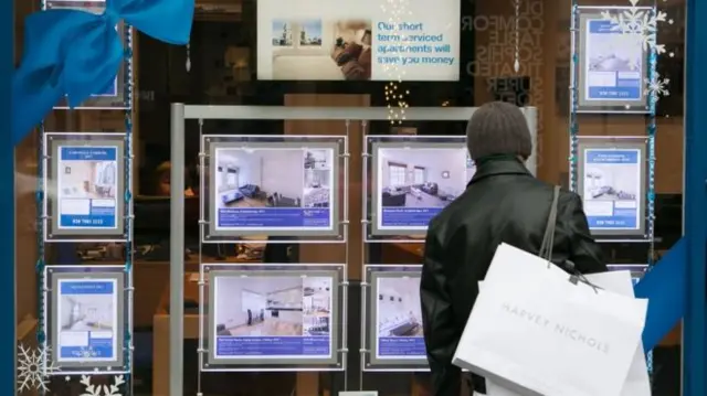 Woman looking at estate agency window