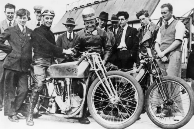 A group of fans surrounding a Norton bike in 1931