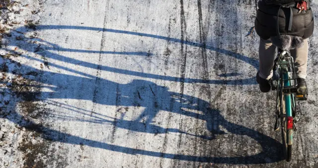 A shadow on ice cast by a cyclist