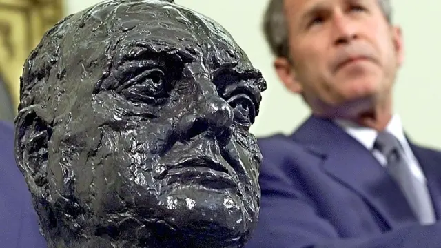 George Bush sits by the bust of Winston Churchill