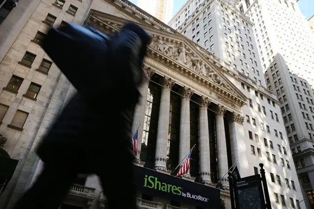 Person walking past New York Stock Exchange