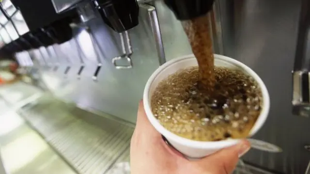 Cup being filled with fizzy drink