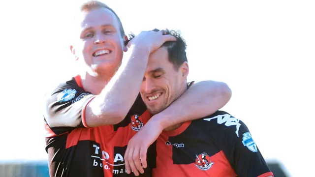 Jordan Owens congratulates Crusaders' goalscorer Declan Caddell at Mourneview Park
