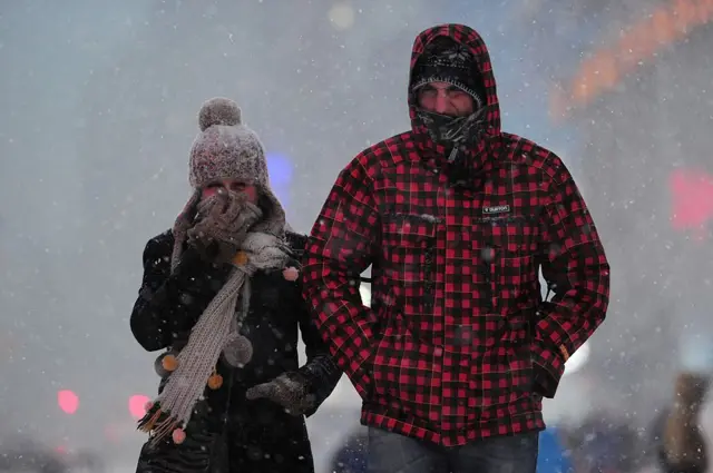 A couple walk in snow