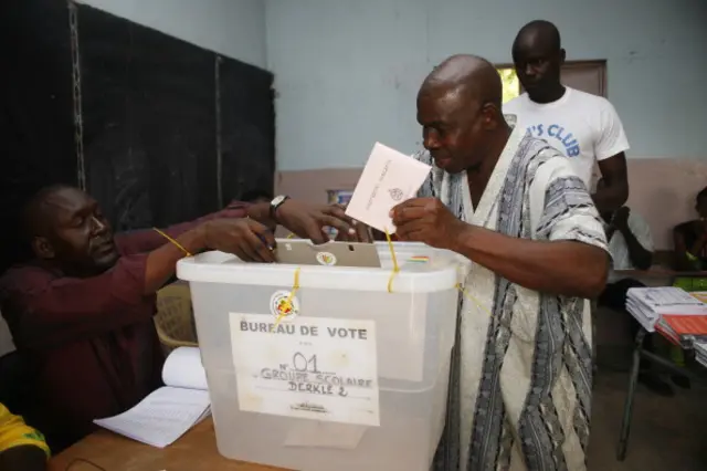 Men vote at a polling station in Dakar on July 1, 2012, during legislative elections.