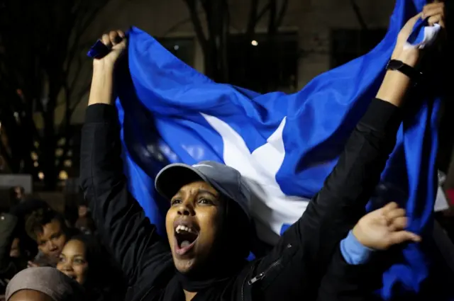 A woman cheers with a Somali flag during a protest held in response to President Donald Trump"s travel ban, in Seattle, Washington, U.S. January 29, 2017.