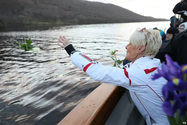 Gina Campbell on a boat, laying flowers on Coniston Water