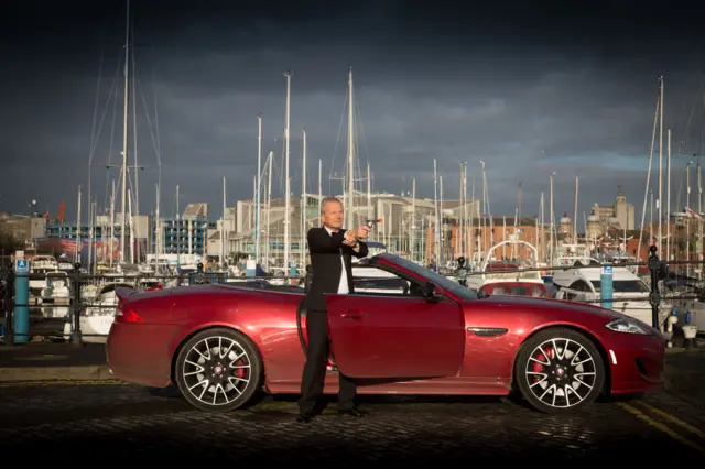 Peter Levy poses as Bond by the marina