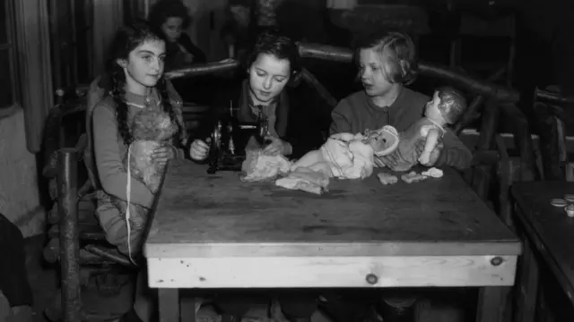 Three young Jewish refugee girls playing with dolls at their camp at Dovercourt Bay, near Harwich, Essex in 1939