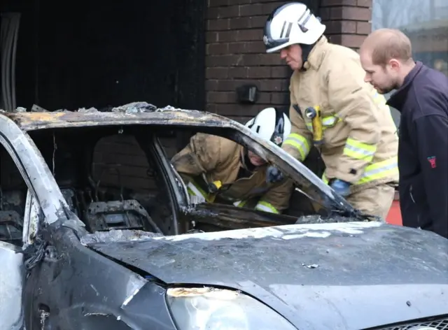 Fire investigators examine the car