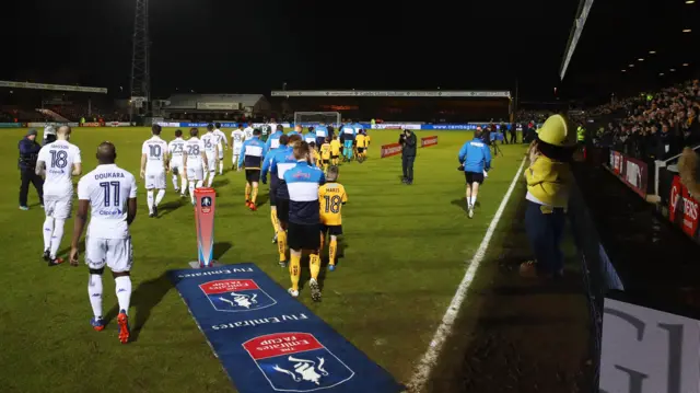 The teams come out onto the pitch