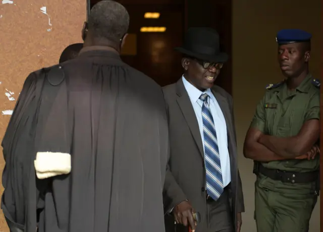 Souleymane Guengueng (2R) of the Association of Victims of the regime of former Chadian dictator Hissene Habre (not seen) walks out the courtroom