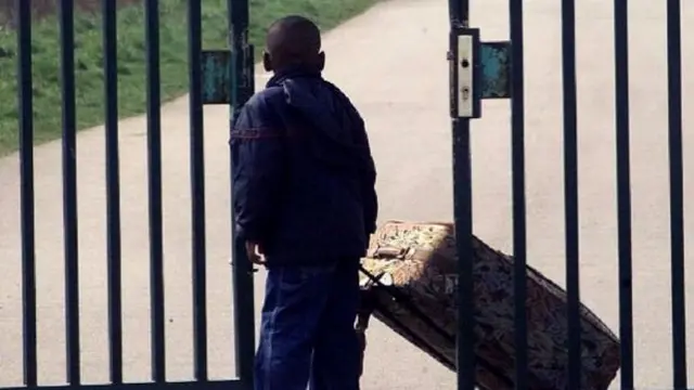 Boy next to gate