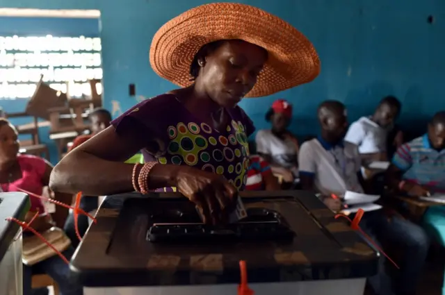 A woman casts her ballot as she votes at a polling station in Monrovia during presidential elections on October 10, 2017.