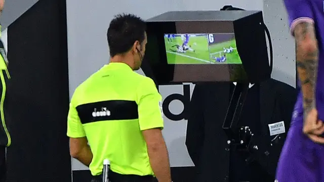 Italian referee assesses a video replay