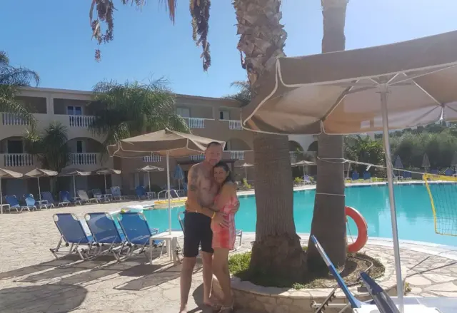 The couple stood by a swimming pool.