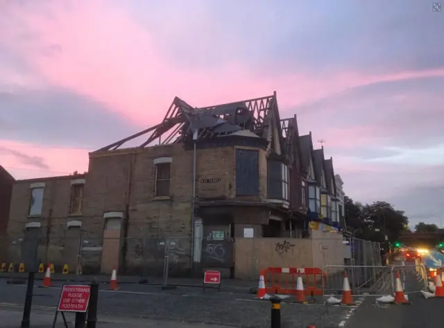 A house on Beverley Road with no roof or windows and barriers around it.